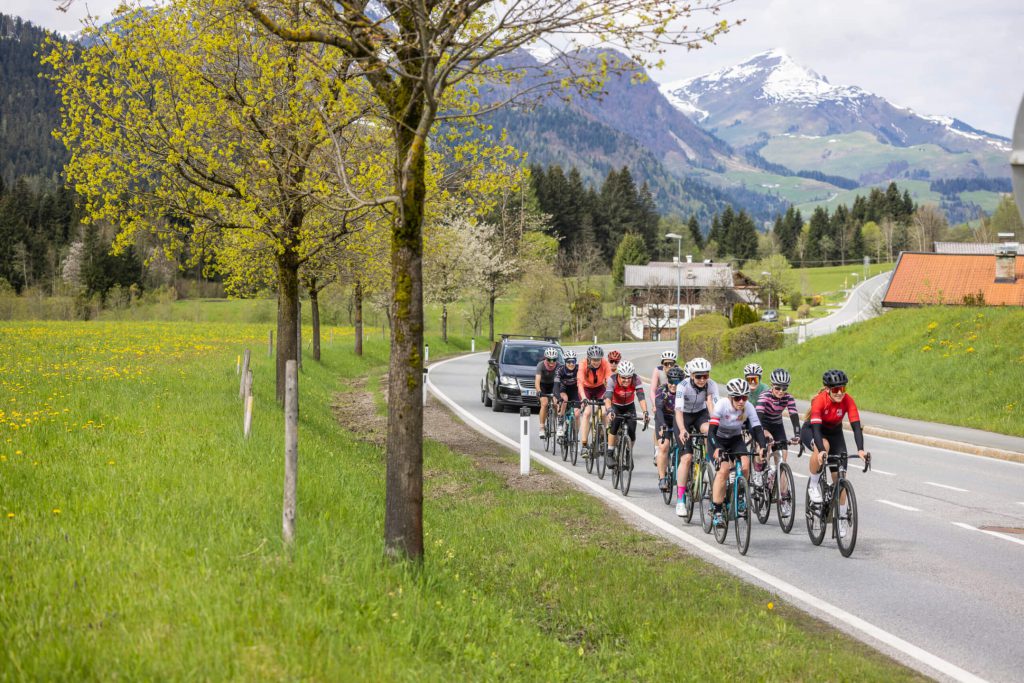 Radfahrende Frauen auf einer Straße im Oberpinzgau, umgeben von Natur und Bergen.